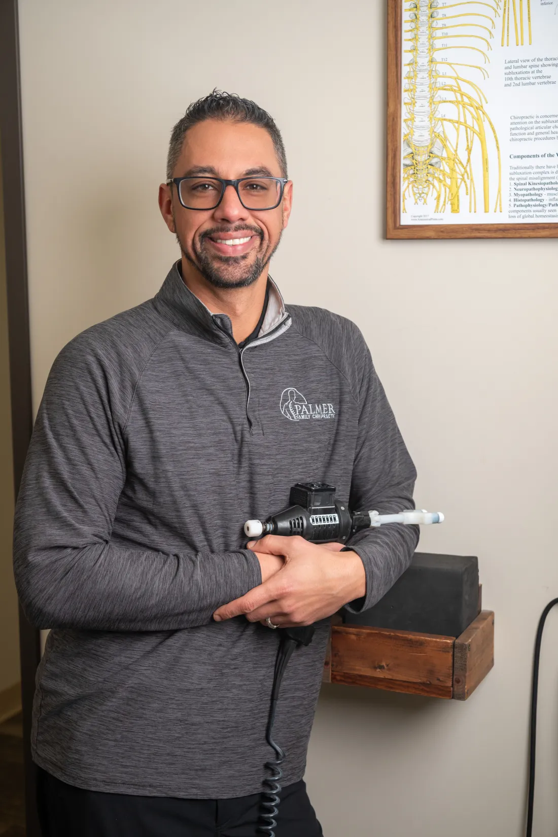 Dr. James Palmer holding a handheld adjusting instrument