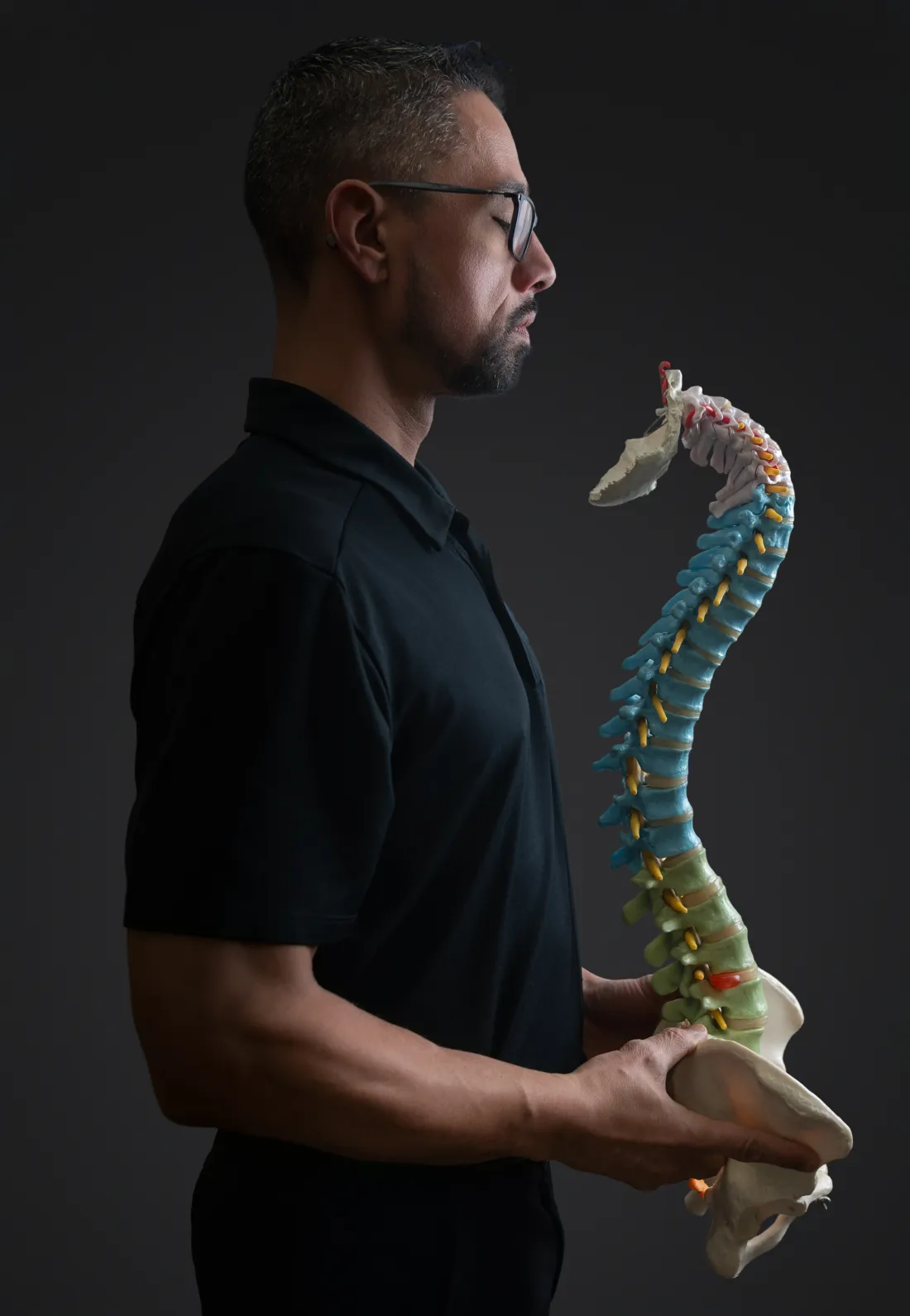 Dr. James Palmer holding an anatomical spine model