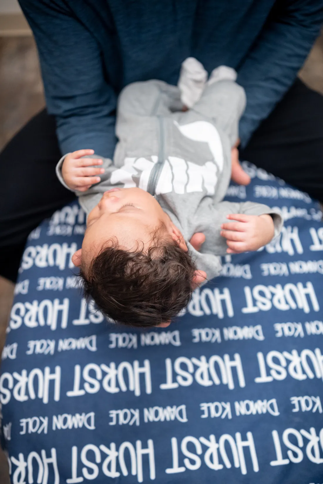 Close view of an infant supported on a caregiver's lap during a chiropractic visit