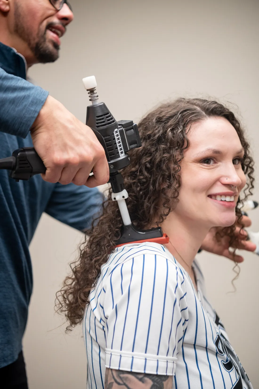 Dr. James Palmer applying a handheld adjusting instrument to a patient's upper back