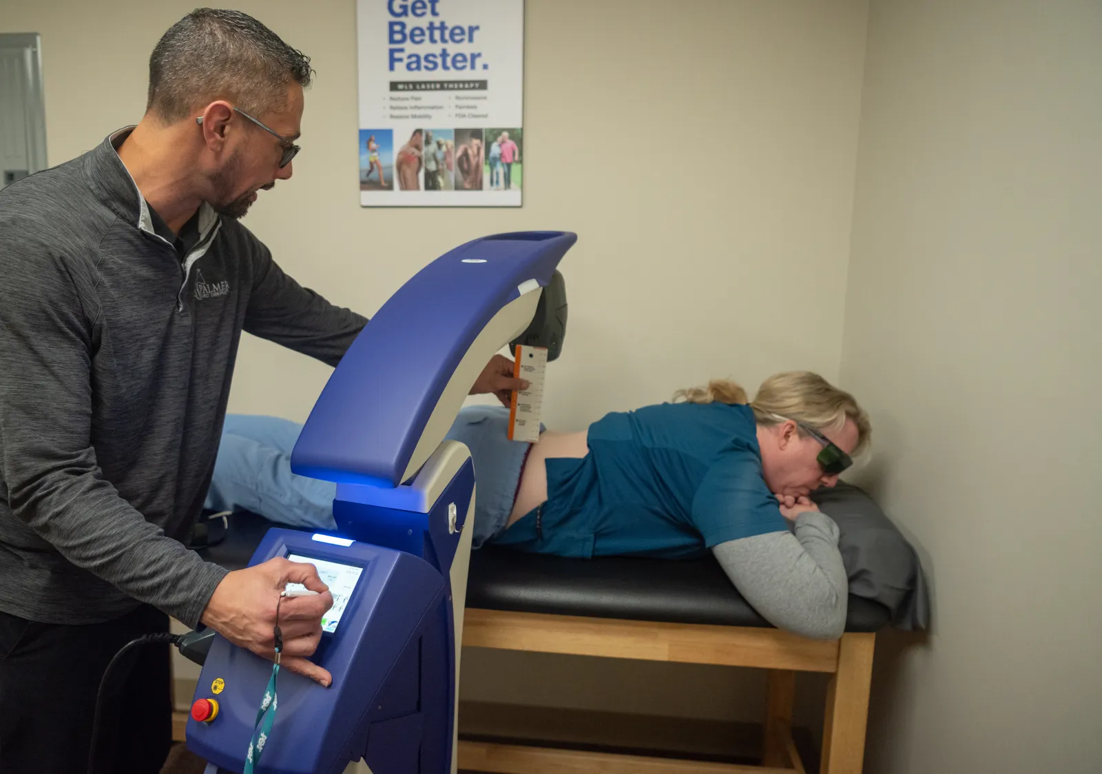 Dr. James Palmer operating therapeutic laser equipment beside a patient wearing protective eyewear