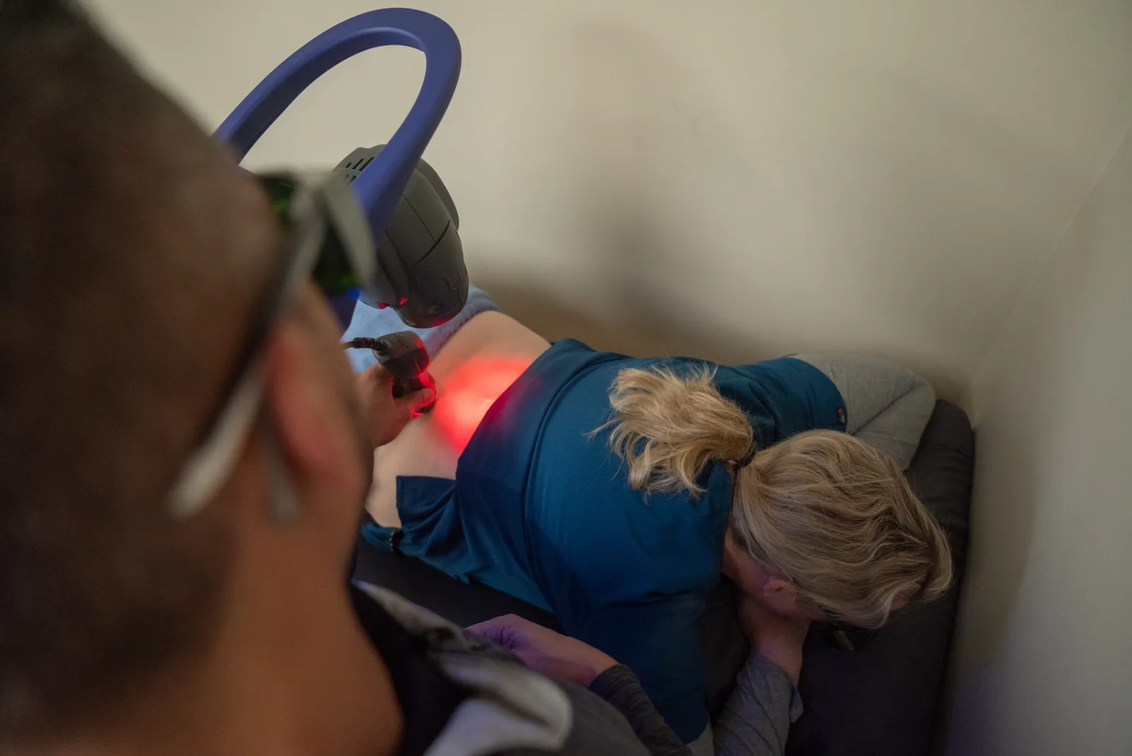 Dr. James Palmer moving a therapeutic laser applicator over a patient's lower back