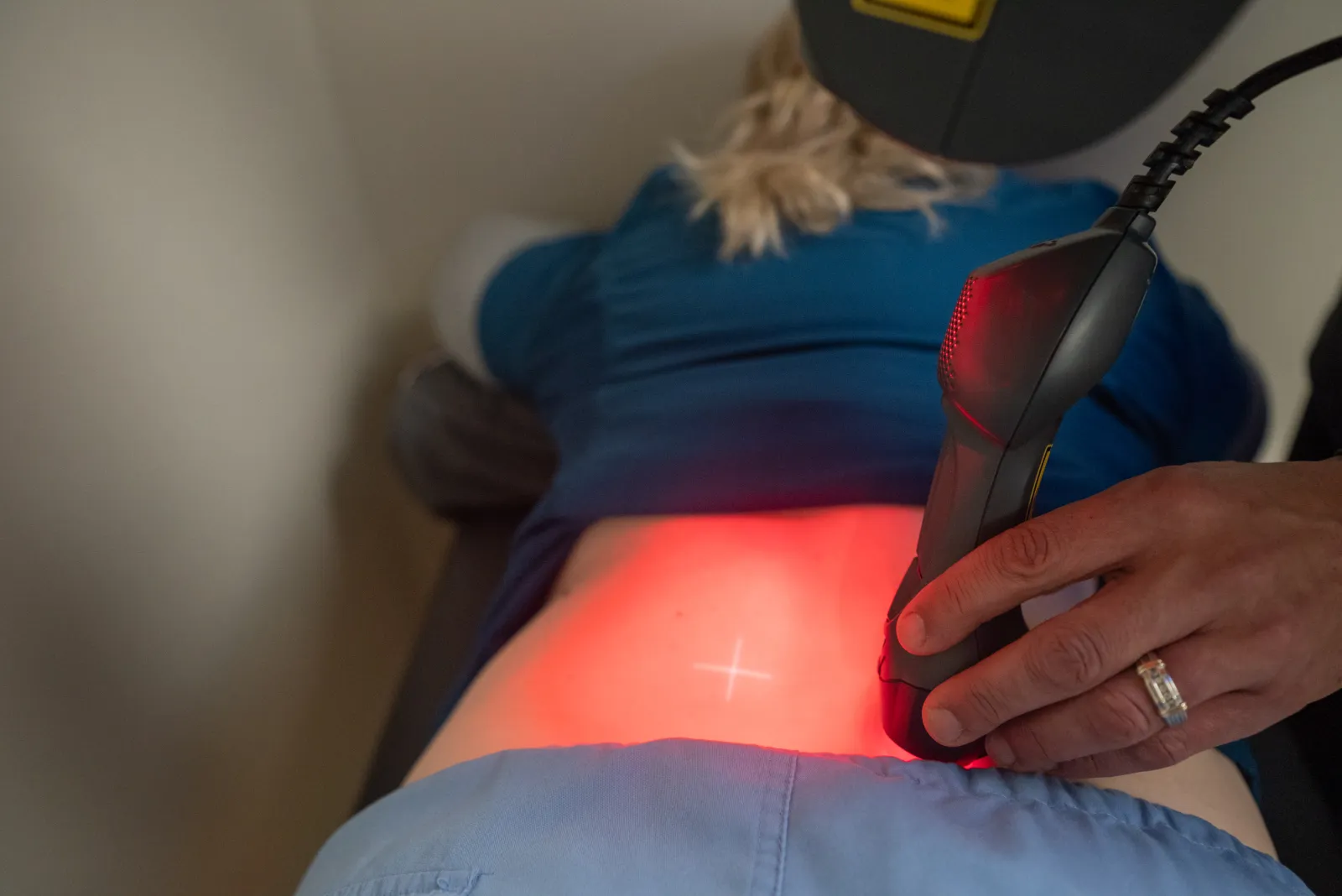 Close view of a therapeutic laser applicator over a patient's lower back
